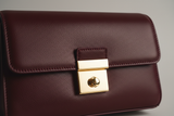 Contemporary Flap Shoulder Bag in Deep Burgundy, flap closure and gold hardware close-up