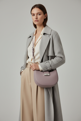 Female model carrying Curved Mini Shoulder Bag in Muted Lavender