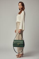 Female model carrying Sculpted Designer Shoulder Bag in Forest Green