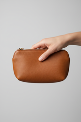 Hand holding Minimal Luxury Pouch in Brown