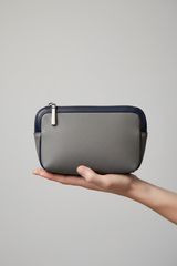 Hand holding Minimal Luxe Pouch in Gray and Navy, portrait view