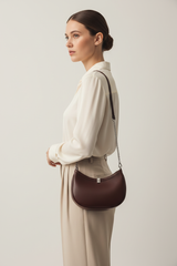 Female model carrying Curved Mini Shoulder Bag in Chocolate Truffle