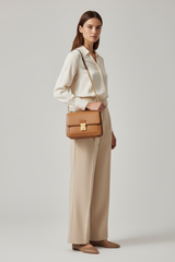 Female model carrying Classic City Shoulder Bag in Camel Tan