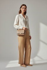 Female model wearing Everyday Mini Crossbody in Soft Taupe