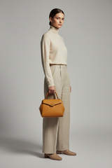 Female model holding Luxury Mini Shoulder Bag in Warm Honey