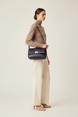 Female model carrying Sculpted Designer Shoulder Bag in Midnight Navy